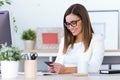 Business young woman using her mobile phone in the office. Royalty Free Stock Photo