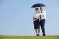 Portrait of businessman and businesswoman under umbrella in park Royalty Free Stock Photo