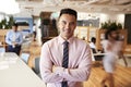 Portrait Of Businessman In Busy Modern Office With Blurred Colleagues Working In Background Royalty Free Stock Photo