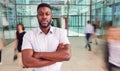 Portrait Of Businessman With Crossed Arms Standing In Lobby Of Busy Modern Office Royalty Free Stock Photo