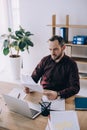 portrait of businessman doing paperwork at workplace with laptop Royalty Free Stock Photo