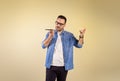 Portrait of businessman dressed in denim shirt sending voicemail via mobile phone. Young man talking over cellphone and gesturing Royalty Free Stock Photo