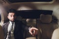 Portrait of businessman driving in car and smiling on his morning commute to work. Young man his finger pointing towards Royalty Free Stock Photo