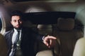 Portrait of businessman driving in car and smiling on his morning commute to work. Young man his finger pointing towards Royalty Free Stock Photo