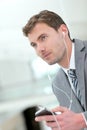 Portrait of businessman with earphones talking on the phone