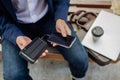 Businessman, freelancer or manager working outdoors in city park. Man with laptop on knees drinking coffee, charging his Royalty Free Stock Photo