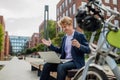 Businessman, freelancer or manager working outdoors in city park. Man with laptop on knees drinking coffee, having video Royalty Free Stock Photo