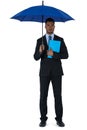 Portrait of businessman holding blue umbrella and a file Royalty Free Stock Photo