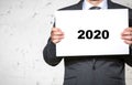 Portrait of businessman holding white placard with year number 2020 Royalty Free Stock Photo