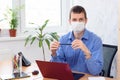 Portrait of a businessman with a medical mask on his face in an office in quarantine Royalty Free Stock Photo