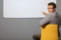 Portrait of businessman pointing at whiteboard and making face in office Royalty Free Stock Photo