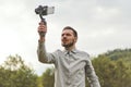 Portrait of businessman recording video presentation at smartphone with steadycam