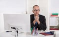 Portrait: Businessman sitting in his office with suit and tie.