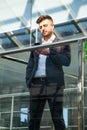 Portrait of a businessman in suit are standing on the background of glass offices. Royalty Free Stock Photo