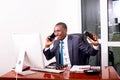 Smiling businessman talking on mobile phone in office Royalty Free Stock Photo