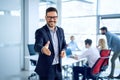 Portrait of businessman welcoming new employee to his business team and company, giving hand forward in modern office. Royalty Free Stock Photo