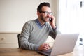 Businessman working on laptop and talking on cellphone Royalty Free Stock Photo