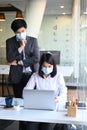 Businesspeople wearing protective mask working together in modern office.