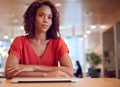 Portrait Of Businesswoman At Desk In Modern Office Work Space With Closed Laptop