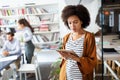 Portrait of businesswoman holding tablet in office and colleagues discussing in background Royalty Free Stock Photo