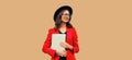 Portrait of businesswoman with laptop wearing red blazer jacket, eyeglasses, round hat on brown background, happy elegant woman Royalty Free Stock Photo