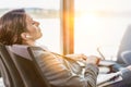 Portrait of businesswoman listening to music on smartphone while sleeping and waiting for boarding in airport Royalty Free Stock Photo