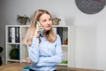 Portrait of businesswoman with mobile phone standing at office. young Caucasian businesswoman holding mobile phone in office. Royalty Free Stock Photo
