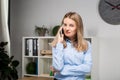 Portrait of businesswoman with mobile phone standing at office. young Caucasian businesswoman holding mobile phone in office. Royalty Free Stock Photo