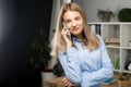 Portrait of businesswoman with mobile phone standing at office. young Caucasian businesswoman holding mobile phone in office. Royalty Free Stock Photo