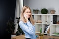 Portrait of businesswoman with mobile phone standing at office. young Caucasian businesswoman holding mobile phone in office. Royalty Free Stock Photo