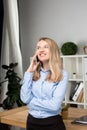 Portrait of businesswoman with mobile phone standing at office. young Caucasian businesswoman holding mobile phone in office. Royalty Free Stock Photo