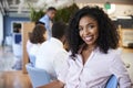 Portrait Of Businesswoman In Modern Office With Colleagues Meeting Around Table In Background