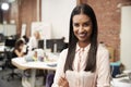 Portrait Of Businesswoman In Modern Open Plan Office With Business Team Working In Background