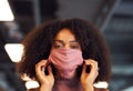 Portrait Of Businesswoman Putting On Face Mask In Modern Open Plan Office During Covid-19 Pandemic Royalty Free Stock Photo