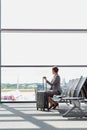 Portrait of businesswoman sititng while waiting for boarding in airport Royalty Free Stock Photo