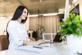 Portrait of a businesswoman sitting on her workplace in the office, typing, looking at pc screen Royalty Free Stock Photo