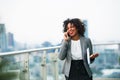 A portrait of a businesswoman standing on a terrace, making a phone call. Royalty Free Stock Photo