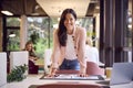 Portrait Of Businesswoman At Table In Office Approving Or Checking Proofs Or Design Layouts