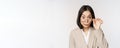 Portrait of businesswoman take-off glasses and looking surprised at camera, standing over white background Royalty Free Stock Photo