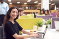 Portrait Of Businesswoman Wearing Phone Headset Talking To Caller In Busy Customer Services Centre Royalty Free Stock Photo