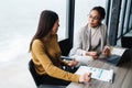 Portrait of businesswomen sitting by desk while working in office