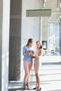 Businesswomen using digital tablet in office corridor