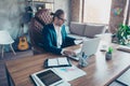 Portrait of busy blonde rich economist in glasses sitting at his