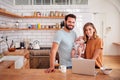 Portrait Of Busy Family In Kitchen At Breakfast With Father Caring For Baby Son Royalty Free Stock Photo