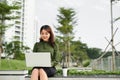 Portrait of busy sales woman sitting at business park and using her laptop while writing text on mobile. Businesswoman working Royalty Free Stock Photo