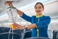 Air hostess showing where to taking an oxygen mask on board