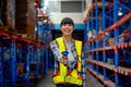 Portrait of Cacuasian warehouse worker hold barcode scaner and point at camera stay on way between shelves in workplace. Concept