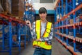 Portrait of Cacuasian warehouse worker hold barcode scaner and smile also look at camera stay on way between shelves in workplace