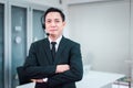 Portrait of call center asian man operator standing with headset looking to camera at office Royalty Free Stock Photo