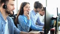 Portrait of call center worker accompanied by her team. Smiling customer support operator at work Royalty Free Stock Photo